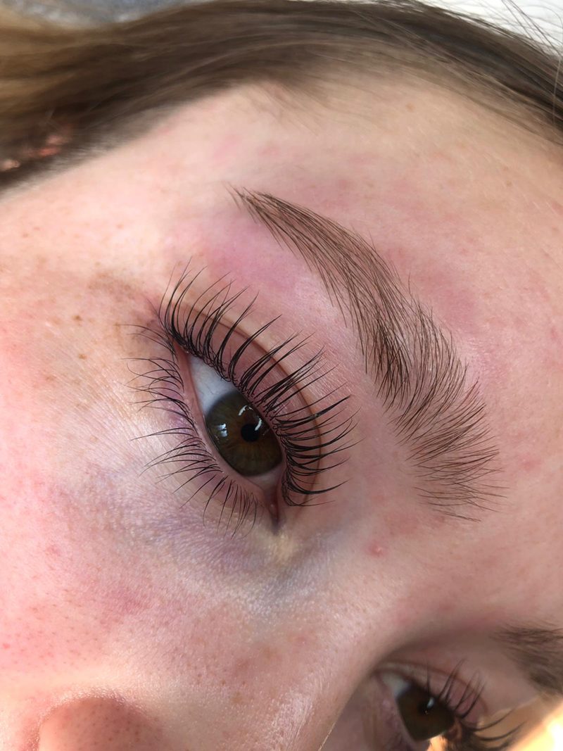 Wenkbrauw die met henna is geverfd en gestyled, met gelifte wimpers eronder