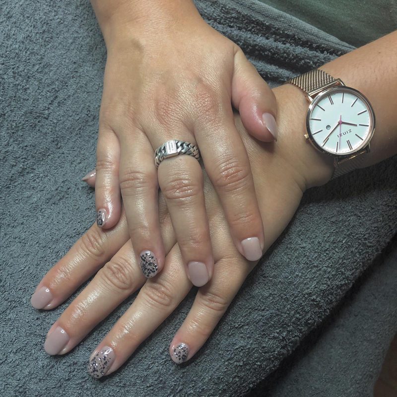 Handen met nude gelakte nagels en een accentnagel met patroon